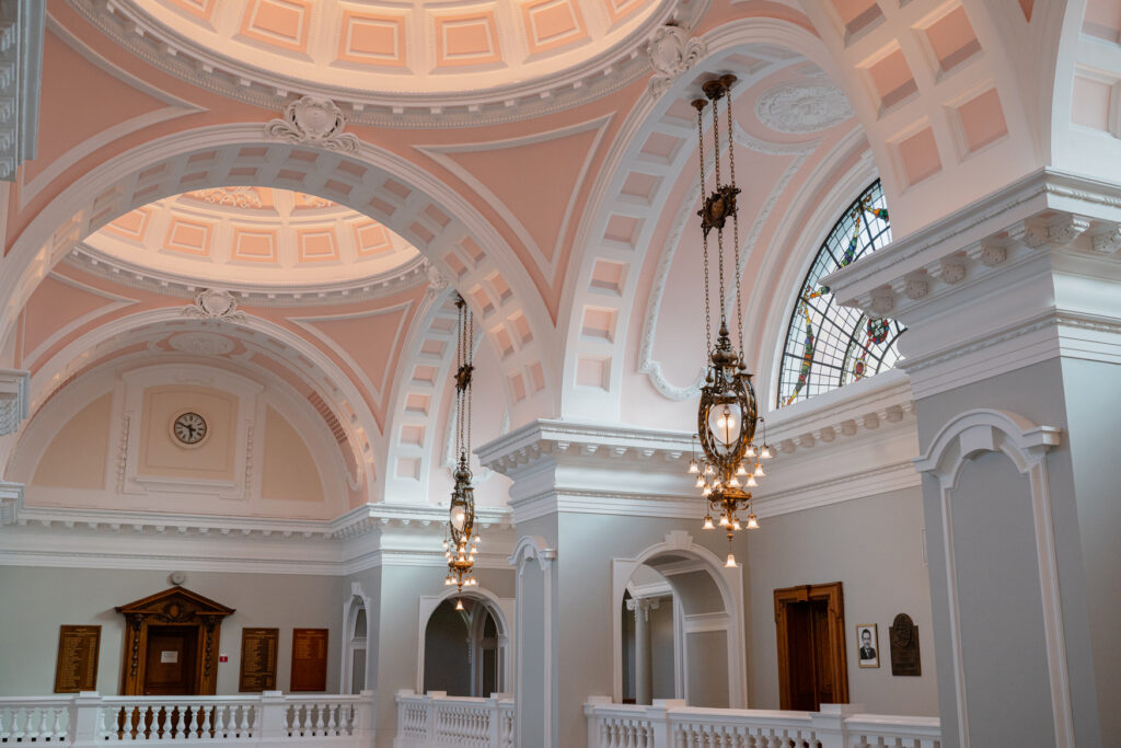 Historic building lighting restoration incorporating refurbished luminaires and discreet architectural lighting within a Grade II listed hall.
